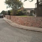 Newly built perimeter wall in red sandstone