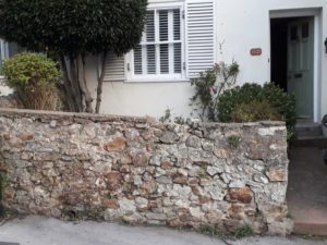 Charmouth: crumbling flint wall..