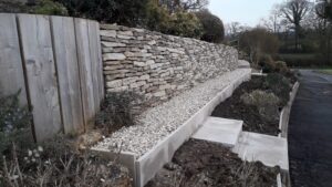 wall rebuilt; pathway and steps and raised kerbing added