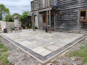 Flagstones lifted; re-laid; and augmented to produce enlarged terrace